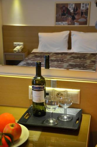 a bottle of wine on a tray with two wine glasses at Kyridis Hotel in Komotini