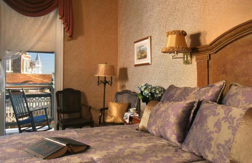 a bedroom with a bed and a balcony at The Queen Victoria in Cape May