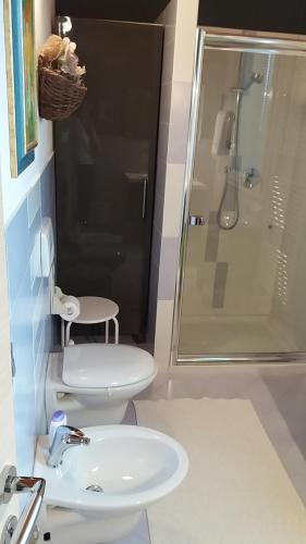 a bathroom with a toilet and a sink and a shower at Villa Posta Vecchia in Loreo
