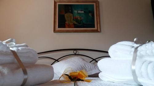 a bed with white towels on it with a painting at Villa Posta Vecchia in Loreo