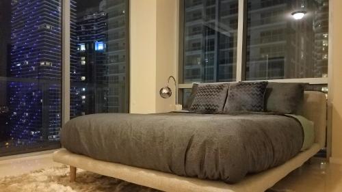 a bed in a room with a large window at Brickell Deluxe Apartment with Free Parking in Miami