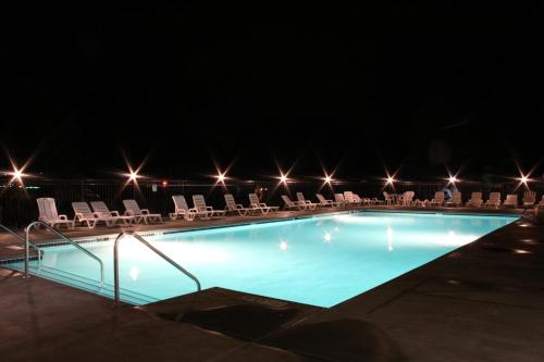 uma piscina à noite com cadeiras e luzes em Blackhawk RV Campground Loft Cabin 11 em Milton