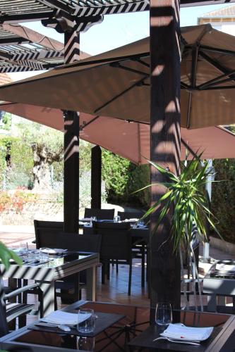 a restaurant with tables and chairs and an umbrella at Bergerie du Château - Lacapelle Marival in Lacapelle-Marival