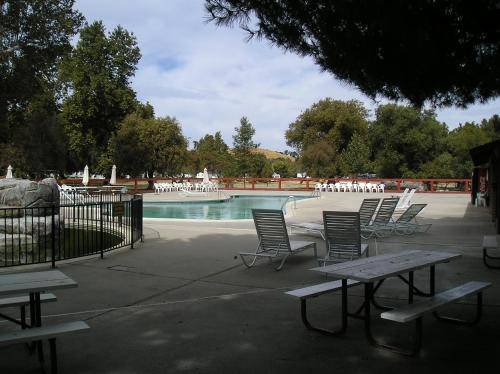 un grupo de sillas sentadas alrededor de una piscina en San Benito Camping Resort Cottage 10 en Paicines