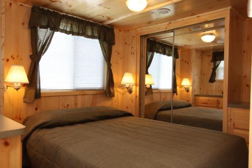1 Schlafzimmer mit 2 Betten in einem Blockhaus in der Unterkunft Blackhawk RV Campground Cabin 1 in Milton