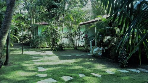 a house in the middle of a yard with trees at Bungalow Natura Village in Sosúa