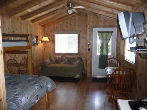 a bedroom with a bed and a couch in a room at Pio Pico Camping Resort Studio Cabin 10 in Jamul