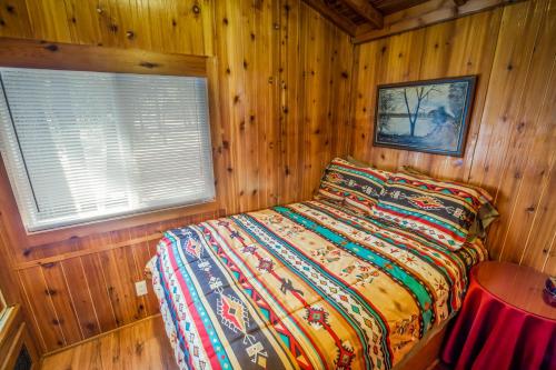a bedroom with a bed in a wooden cabin at Pio Pico Camping Resort One-Bedroom Cabin 13 in Jamul