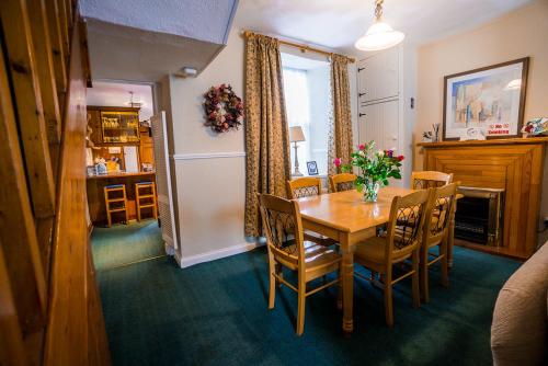 a dining room with a wooden table and chairs at The Small House in Listowel