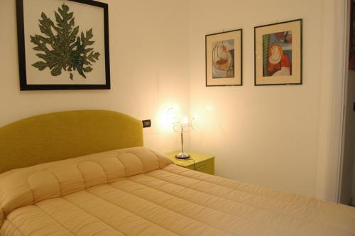 アラッシオにあるApartment Serenaのベッドルーム1室(ベッド1台付)が備わります。壁に2枚の写真が飾られています。