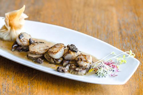 a plate of food on a wooden table at Hôtel Minvielle - Résidence Les Oliviers in Ségos