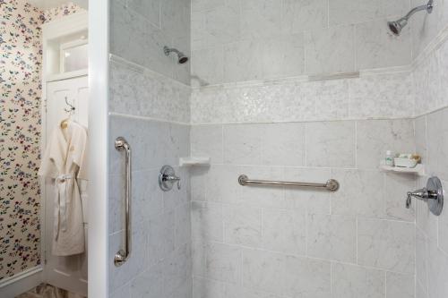 a bathroom with a shower with white tiles at The Queen Victoria in Cape May