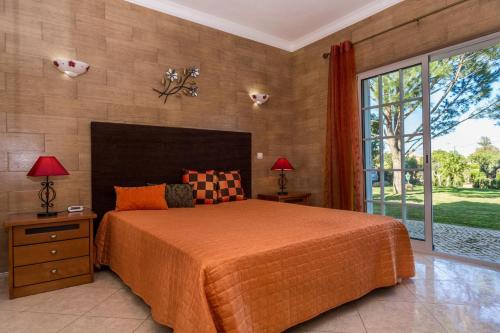 a bedroom with a large bed and a large window at Akivillas Pera Relax in Pêra