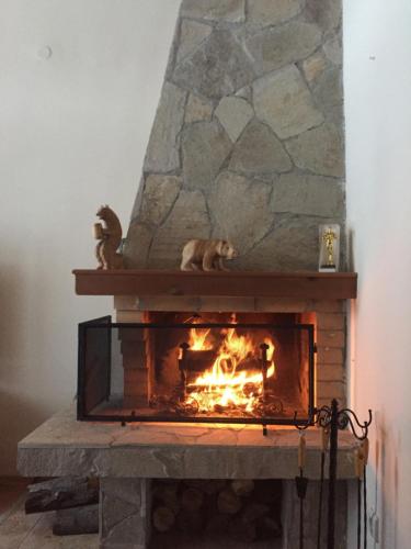 a stone fireplace with a fire in it at Chalet Mechka in Borovets