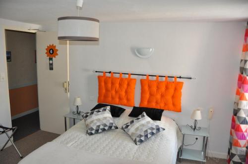 a bedroom with a bed with orange pillows at Le Florentin in Florentin-la-Capelle