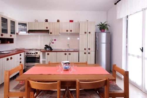 eine Küche mit einem Tisch mit Stühlen und einem Kühlschrank in der Unterkunft Apartment Patricija 1208 in Banjole