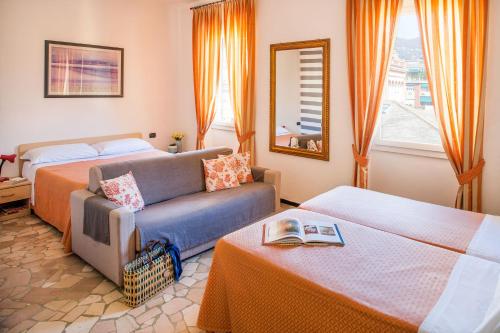 ラパッロにあるアルベルゴ ラ ピアッツェッタのベッドとソファ付きのホテルルーム