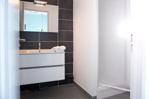 a bathroom with a sink and a mirror at Résidence Coté Mer in La Grande-Motte