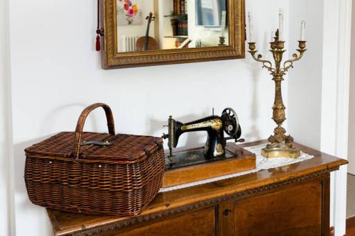 a table with a sewing machine and a basket and a mirror at B&B Arts And Music in Ancona