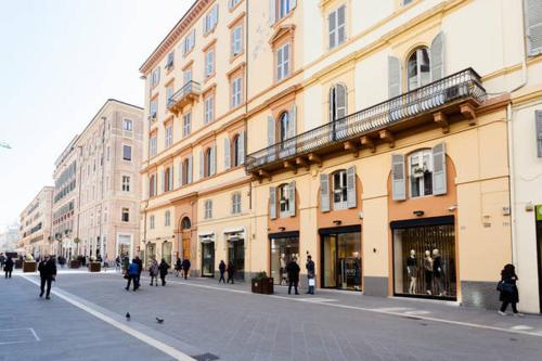 a group of people walking down a street next to buildings at B&B Arts And Music in Ancona