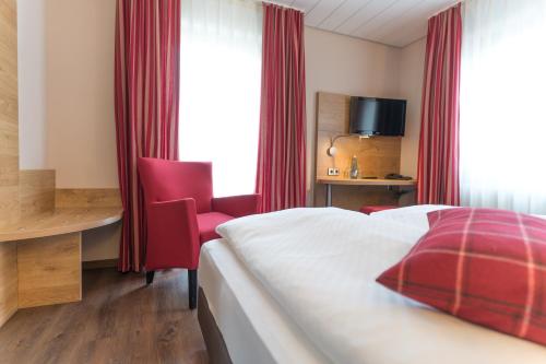 a hotel room with a bed and a desk and a window at Hotel Hirsch in Kehl am Rhein
