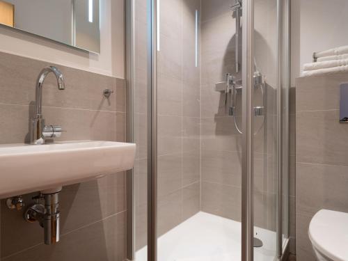 a bathroom with a shower and a sink at Hotel Hirsch in Kehl am Rhein