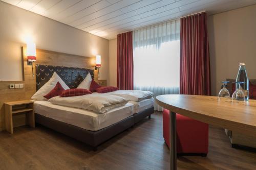 a hotel room with a bed and a table at Hotel Hirsch in Kehl am Rhein