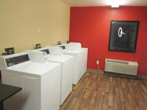 a laundry room with a row of washers and a red wall at Extended Stay America Suites - Seattle - Lynnwood in Lynnwood