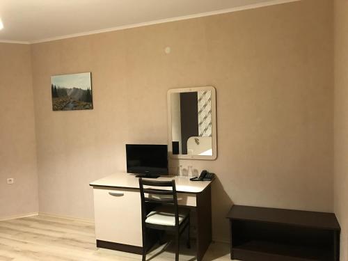 Habitación con escritorio, ordenador y espejo. en Hotel Body M en Vratsa