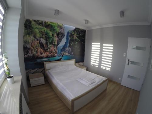 - une chambre avec un lit orné d'une peinture murale dans l'établissement A3XD Apartament 2, à Częstochowa