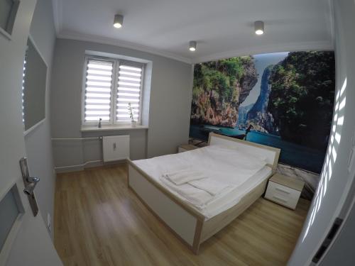 - une chambre avec un lit orné d'une peinture murale dans l'établissement A3XD Apartament 2, à Częstochowa