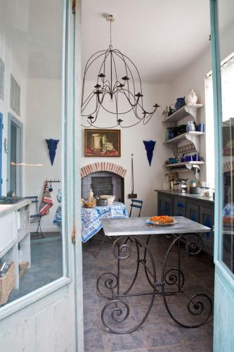 - une cuisine avec une table et une cheminée dans l'établissement Maison d'Hôtes La Guérandière, à Guérande