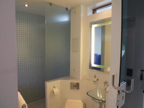a bathroom with a sink and a toilet and a window at Hotel CPH Living in Copenhagen