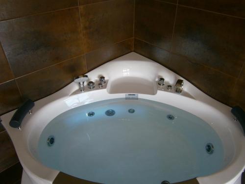 uma banheira no canto de uma casa de banho em Hotel Ioanna em Olympiakí Aktí