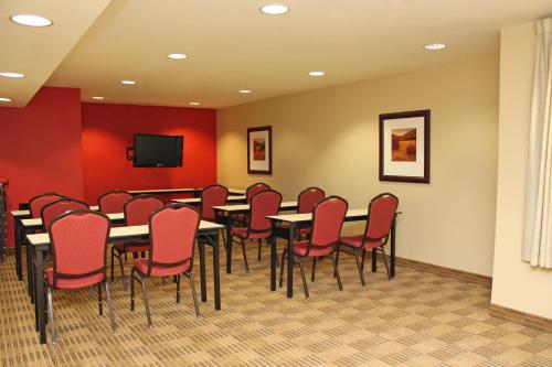 a conference room with tables and chairs and a tv at Extended Studio Hotel Suites - Los Angeles - San Dimas in San Dimas