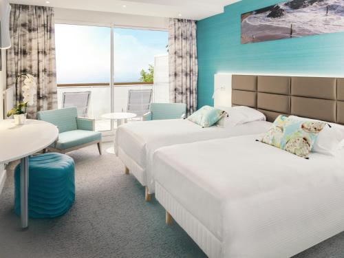 Cette chambre d'hôtel comprend deux lits, une table et des chaises. dans l'établissement Alliance Pornic Hôtel Thalasso & Spa, à Pornic