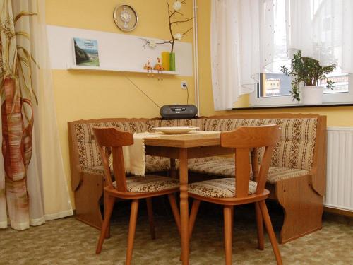 a wooden table with two chairs in a room at Siebers-Ferienwohnung in Saupsdorf
