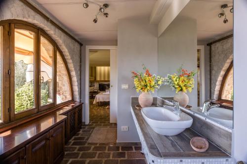 a bathroom with a sink and a tub with flowers on a counter at Villa La Foce in Castiglion Fiorentino