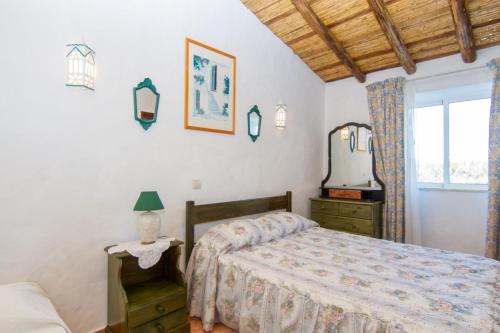 um quarto com uma cama, um espelho e uma janela em Akivillas Silves Relax em Silves