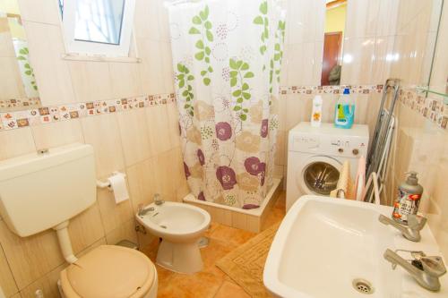 uma casa de banho com um WC, um lavatório e uma máquina de lavar roupa em Akivillas Silves Relax em Silves