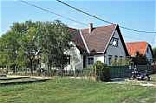 uma casa grande num quintal com um campo verde em Privatzimmer Csikos em Hortobágy