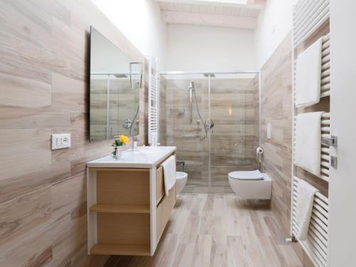 a bathroom with a shower and a sink and a toilet at Les Suites in Asola