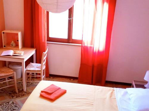 a bedroom with a bed and a desk and a window at Casa "Le tre Muse" in Deruta