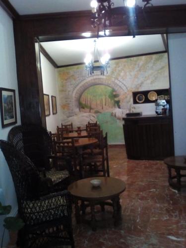 a dining room with tables and chairs and a mural at Hotel Andalucía in Cazorla