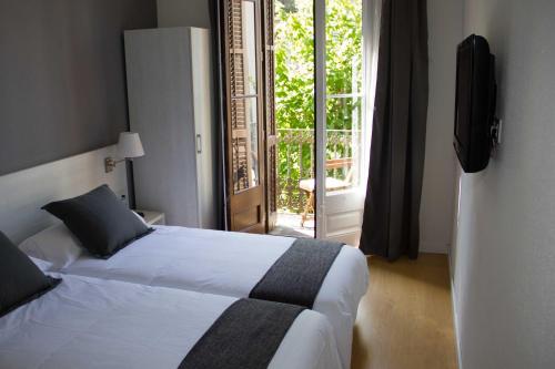 a hotel room with a bed and a balcony at Hostalin Barcelona Diputacion in Barcelona