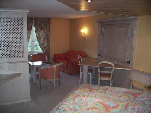 a small room with a table and a couch at Hôtel des Vosges in La Petite-Pierre