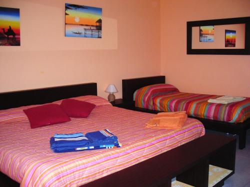 a bedroom with two beds with clothes on the bed at B&B CasAnsaldo in Giarre