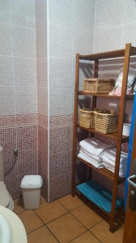a bathroom with a toilet and a shelf with towels at Casa Dulce in Gran Tarajal