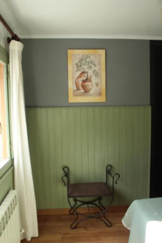 a room with a chair and a picture on the wall at Hostal-Restaurante Fogón de Gredos in Guisando