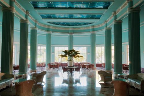 a large room with chairs and a table with a plant at Grande Hotel Termas de Araxá in Araxá